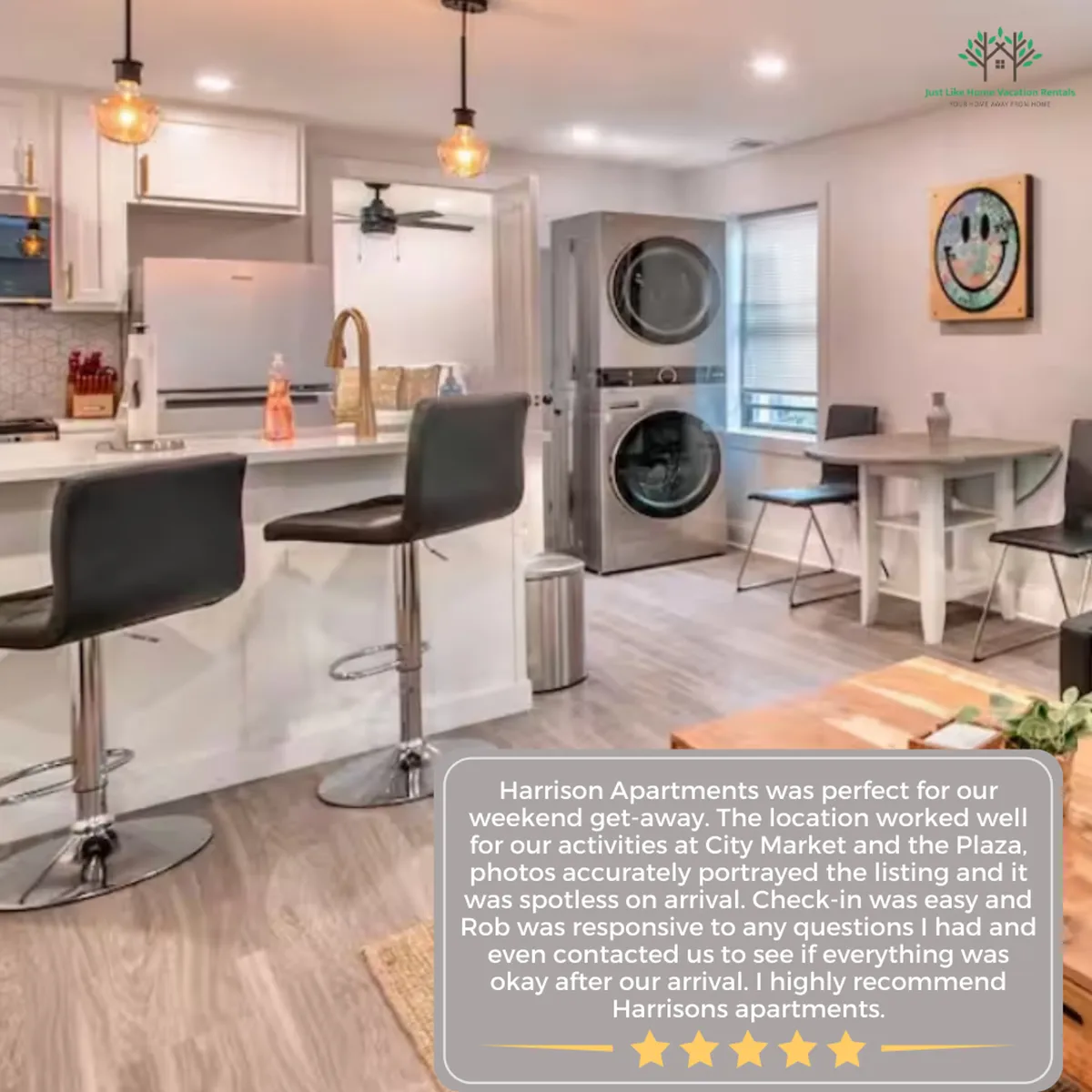 An inviting open-concept space featuring a kitchen island with bar stools, a washing machine, and a dining table. The room is bathed in both natural and artificial light, offering zones for cooking, casual dining, and easy conversation.